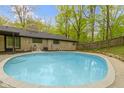 Relaxing backyard swimming pool with concrete patio and privacy fence at 4475 Berkshire Rd, Indianapolis, IN 46226
