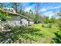 Side yard with siding, mature trees, and a glimpse of backyard features a shed and chain-link fence at 4941 Mathews Ave, Indianapolis, IN 46227