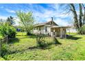 Backyard view of home featuring fenced yard, covered porch, and mature trees adding to privacy at 4941 Mathews Ave, Indianapolis, IN 46227