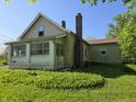 View of the back of the home showing the chimney and vinyl siding at 5103 W Vermont St, Indianapolis, IN 46224