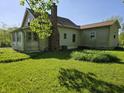 Rear exterior showcasing a spacious yard and house with vinyl siding at 5103 W Vermont St, Indianapolis, IN 46224