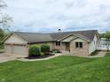 Traditional brick home featuring an attached three-car garage and lakeside deck at 515 E Hoover Dr, Nineveh, IN 46164