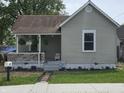 Cozy one-story house featuring a charming porch, flowering plants, and a well-manicured lawn at 533 W Pike St, Martinsville, IN 46151