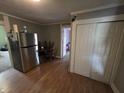 Functional kitchen with stainless steel refrigerator, laminate flooring, and adjacent dining area at 533 W Pike St, Martinsville, IN 46151
