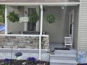 Inviting front porch with stone accents, hanging flower baskets, and a quaint seating area at 533 W Pike St, Martinsville, IN 46151