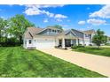 Inviting two-story home with a spacious driveway, lush lawn, and charming front porch at 5580 Pintail Ln, Greenwood, IN 46143