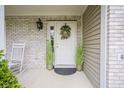 Inviting covered front porch with brick accent, rocking chair, and decorative wreath on the front door at 6270 Lancaster Pl, Zionsville, IN 46077