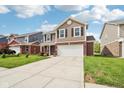 Attractive two-story home showcasing a long driveway, well-maintained lawn, and classic architectural details at 6540 Mccreery Ct, Indianapolis, IN 46221