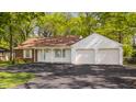 Charming ranch home featuring brick and white siding, an attached two-car garage and mature trees at 728 E Main St, Carmel, IN 46032