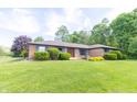 Well-manicured front lawn and landscaping highlight this charming brick home at 8292 E 100 S, Greenfield, IN 46140