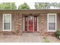 Close-up of the home's entry featuring a red door with glass inserts and brick and tan siding at 912 Ramblin Rd, Greenwood, IN 46142