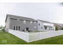 Spacious backyard featuring a white picket fence, lush lawn, and a patio with outdoor seating at 9176 Springbrook Dr, Pendleton, IN 46064