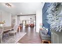 Open-concept entryway with wood floors, modern decor, and seamless flow into the dining and living spaces at 9804 Canyon Ln, Pendleton, IN 46064