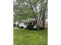 Charming two-story home with a manicured lawn, mature trees, and an inviting front porch at 10118 Leeward Blvd, Indianapolis, IN 46256