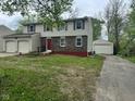 Two-story home with a two car garage and separate single car garage with a red front door at 10361 E 30Th St, Indianapolis, IN 46229