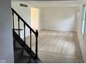 Bright living room featuring wood floors, a staircase and white walls at 10361 E 30Th St, Indianapolis, IN 46229