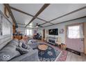 Inviting living room with comfortable seating, decorative ceiling beams, natural light, and stylish furnishings at 109 N Avon Ave, Avon, IN 46123