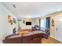 Comfortable living room featuring a fireplace, plush leather seating, and natural light from the window at 10935 Cornell St, Carmel, IN 46280
