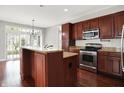 Spacious kitchen featuring dark wood cabinets, stainless steel appliances, and an island at 127 Coatsville Dr, Westfield, IN 46074