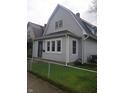 Charming two-story home with vinyl siding, well-maintained lawn, chain-link fence, and mature tree at 1433 Charles St, Indianapolis, IN 46225