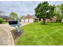 Beautifully landscaped front yard complements the brick home with a three-car garage at 1544 Olive Branch Cir, Greenwood, IN 46143
