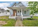 Charming light-blue house featuring a small porch with classic columns and clean landscaping at 1617 E Kelly St, Indianapolis, IN 46203