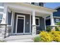 Inviting covered front porch with stone columns and comfortable rocking chairs, perfect for relaxing outdoors at 1648 Rossmay Dr, Westfield, IN 46074