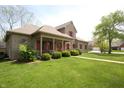 Charming brick home featuring a well-manicured lawn, red shutters, and a welcoming front porch at 17003 Whitebark Ct, Westfield, IN 46074