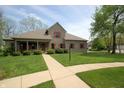 Charming brick home featuring a well-manicured lawn, red shutters, and a welcoming front porch at 17003 Whitebark Ct, Westfield, IN 46074