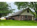 Expansive backyard view of a brick home with a wood deck and mature trees at 1934 Constitution St, Greenfield, IN 46140