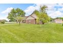 A spacious, grassy side yard showcases the exterior of the home at 1934 Constitution St, Greenfield, IN 46140