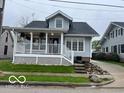 Charming two-story home featuring a covered front porch with white railings and meticulous landscaping at 223 E Fordice St, Lebanon, IN 46052
