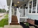 Inviting front porch with wooden steps, white railings, and tasteful landscaping adds curb appeal at 223 E Fordice St, Lebanon, IN 46052