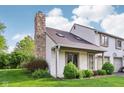 A lovely townhome featuring a striking stone chimney and mature landscaping at 2430 Spring Hill Ct, Indianapolis, IN 46268