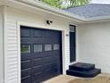 Attached one-car garage with a black garage door and steps up to the front door at 2431 Timbercrest Dr, Columbus, IN 47203
