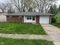 A well-kept single-story home shows off its brick facade, shutters, and attached one car garage at 2453 Larnie Ln, Indianapolis, IN 46219