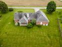 Aerial view of the home and screened-in back porch, surrounded by a large, green lawn at 2708 N Buck Creek Rd, Greenfield, IN 46140