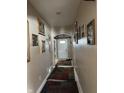 Long hallway with picture frames hanging on the wall with a white door at the end at 2761 Winding Creek Ln, Greenfield, IN 46140