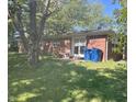 Exterior shot of the brick back of the home with sliding glass door, and blue trash bins visible at 2928 Cicero Rd, Noblesville, IN 46060