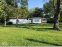 Shot of the home from across the front yard with white siding and trees, garage on left side of frame at 2928 Cicero Rd, Noblesville, IN 46060