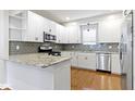 Modern kitchen featuring white cabinets, granite countertops, stainless steel appliances, and hardwood floors at 2940 N Park Ave, Indianapolis, IN 46205