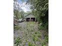 Detached garage with two bays and gravel driveway surrounded by trees at 3031 E 38Th St, Indianapolis, IN 46218