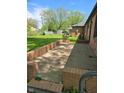 This backyard offers a quaint brick patio and lush greenery for enjoyable outdoor living at 3128 W 12Th St, Anderson, IN 46011
