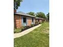 Charming brick home exterior showcasing manicured lawn, detailed brickwork, and blue shutter accents at 3128 W 12Th St, Anderson, IN 46011