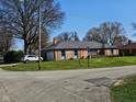 Exterior view of brick single story home with shutters and a large front lawn, viewed from the street at 3128 W 12Th St, Anderson, IN 46011