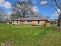 View of a brick single story home with well manicured lawn and landscaping at 3128 W 12Th St, Anderson, IN 46011