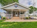 Inviting front porch with white railing, adorned with charming decorations at 3140 W 18Th St, Anderson, IN 46011