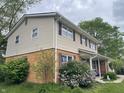 View of a charming two-story home, showcasing a brick and siding exterior with mature trees and landscaping at 3232 St Jude Dr, Indianapolis, IN 46227