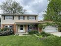 Charming two-story home with a well-maintained lawn, landscaping, and a cozy front porch area at 3232 St Jude Dr, Indianapolis, IN 46227