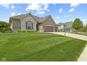 Charming home featuring a three-car garage, stone and brick facade, and well-manicured lawn at 3424 S Lookout Pass, New Palestine, IN 46163